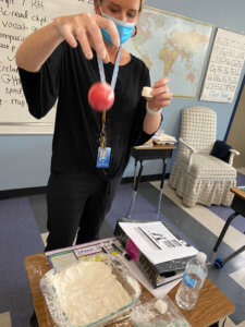 Teacher performing experiment with flour and ball