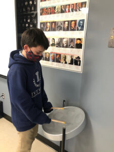 Student playing new drum