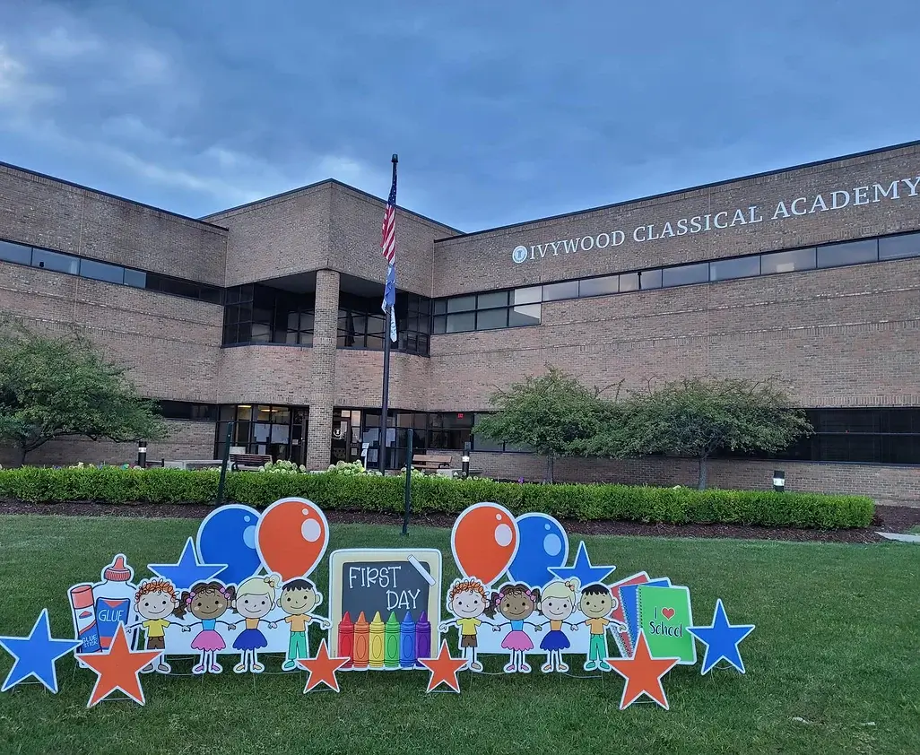 Ivywood school building with fun first day of school signs in yard